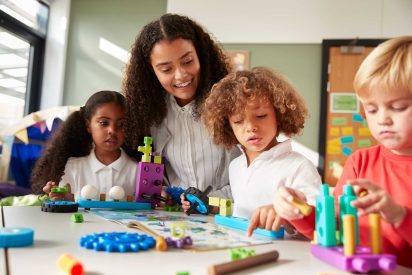 female-teacher-sitting-at-table-in-play-room-with-2024-10-19-13-01-30-utc2.jpg